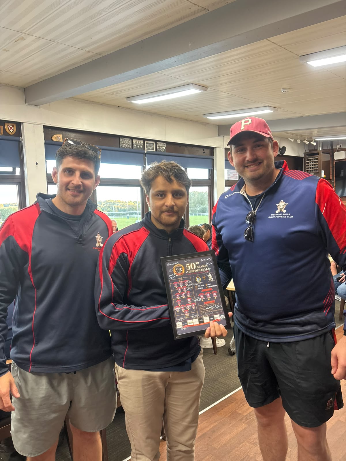 Alex Powell is presented with a framed team sheet, signed by his teammates, for making his 1st XV debut.